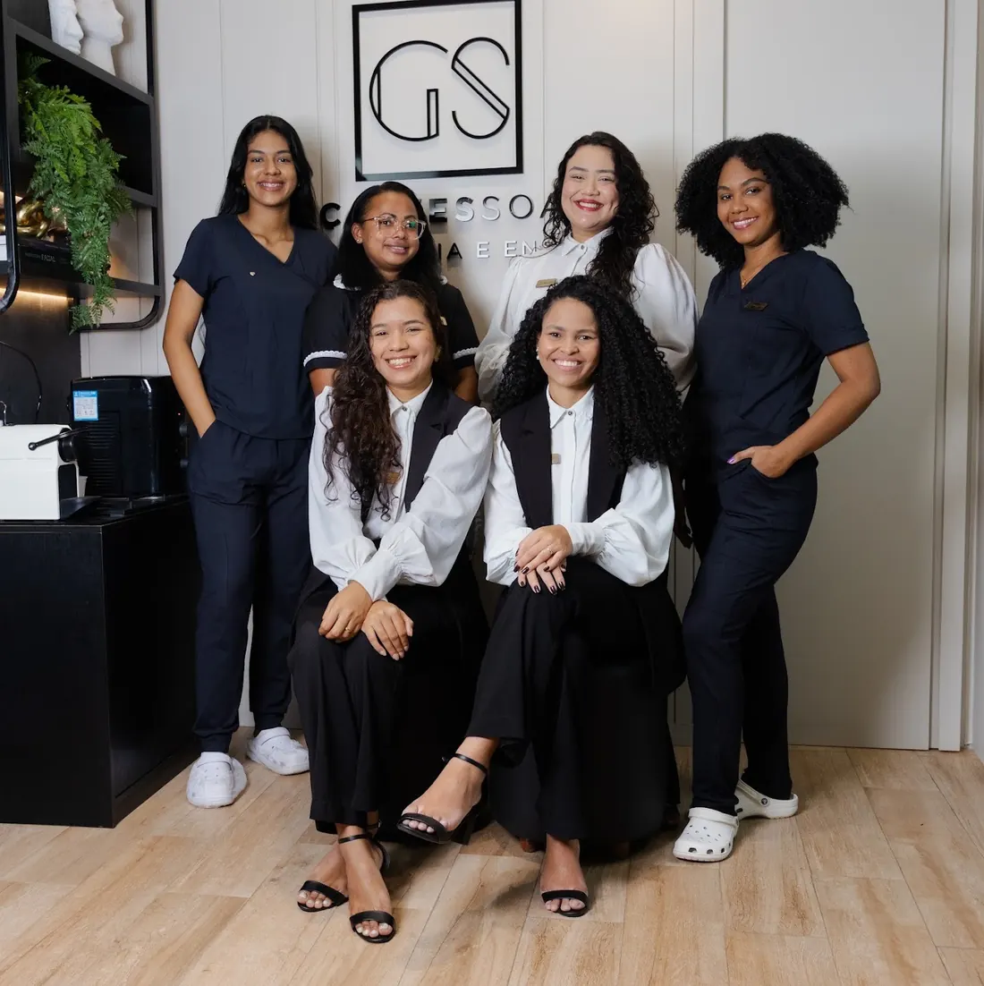 Equipe da GS Clínica em frente ao logotipo